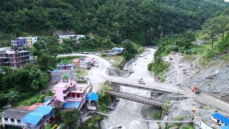 Aerial-shot-of-a-bridge-through-Gandaki-River-on-the-Jomsom-way-in-Marpha-Village-in-Nepal,-drone-flying-forward