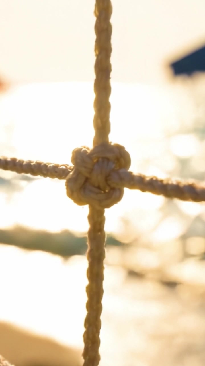 Una prospettiva ravvicinata di un nodo decorativo su uno sfondo illuminato dal sole, che evidenzia texture e maestria artigianale in ambienti nautici.