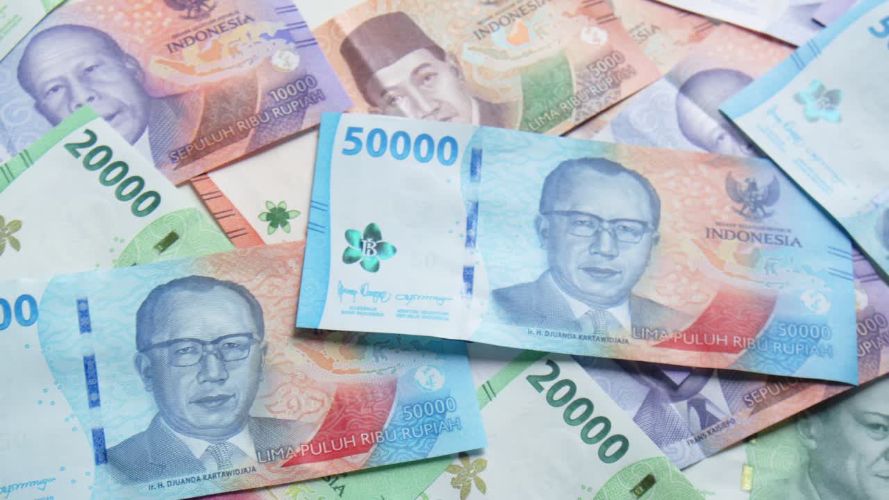 Kameraschwenk über einen Boden voller bunter indonesischer Rupiah-Banknoten oder Geld.
