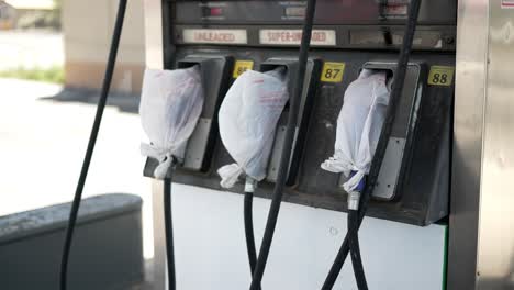 gas pumps at shut down fuel petrol station with plastic bags on all the nozzles due to gas shortage crisis and covid pandemic