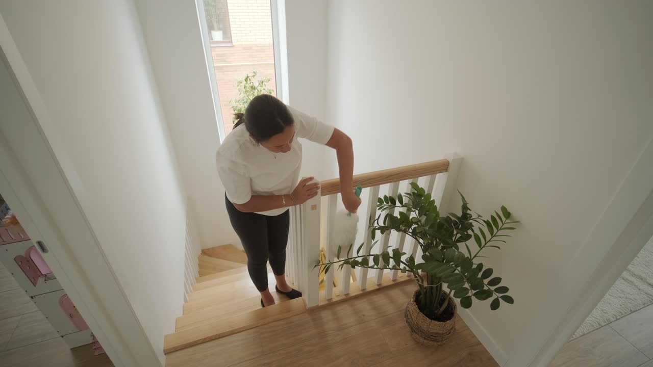 una hermosa mujer embarazada ordenando su casa, ocupada en las tareas domésticas. la escena captura la vida doméstica, la maternidad y el equilibrio de la rutina y la preparación durante el embarazo