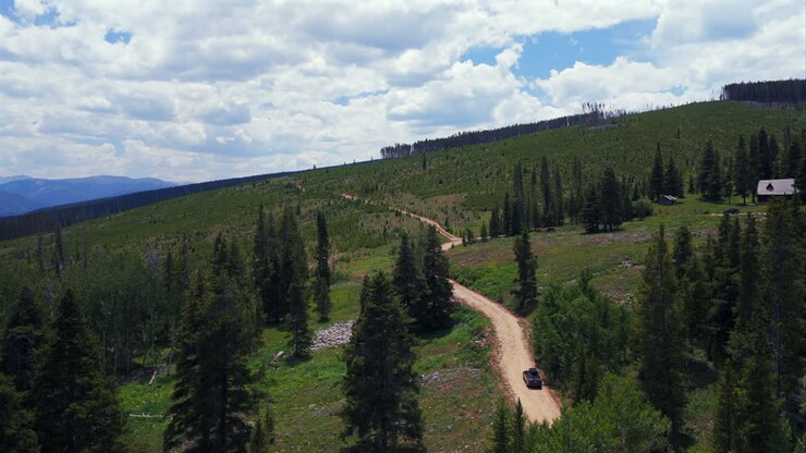 Mount of the Holy Cross Notch Mountain, torrente Falls Creek Trail, Half Moon Pass, auto AWD che percorre una strada sterrata, drone aereo che riprende un'auto, Montagne Rocciose, Colorado, Vail, Minturn, mattina d'estate, cielo blu, avanti, seguire