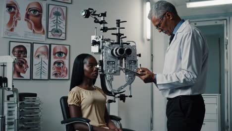 an optometrist conducts an eye exam on a patient in a clinic.