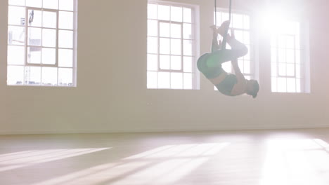 aerial yoga woman practicing hanging upside down using hammock enjoying healthy fitness lifestyle exercising in studio training meditation at sunrise
