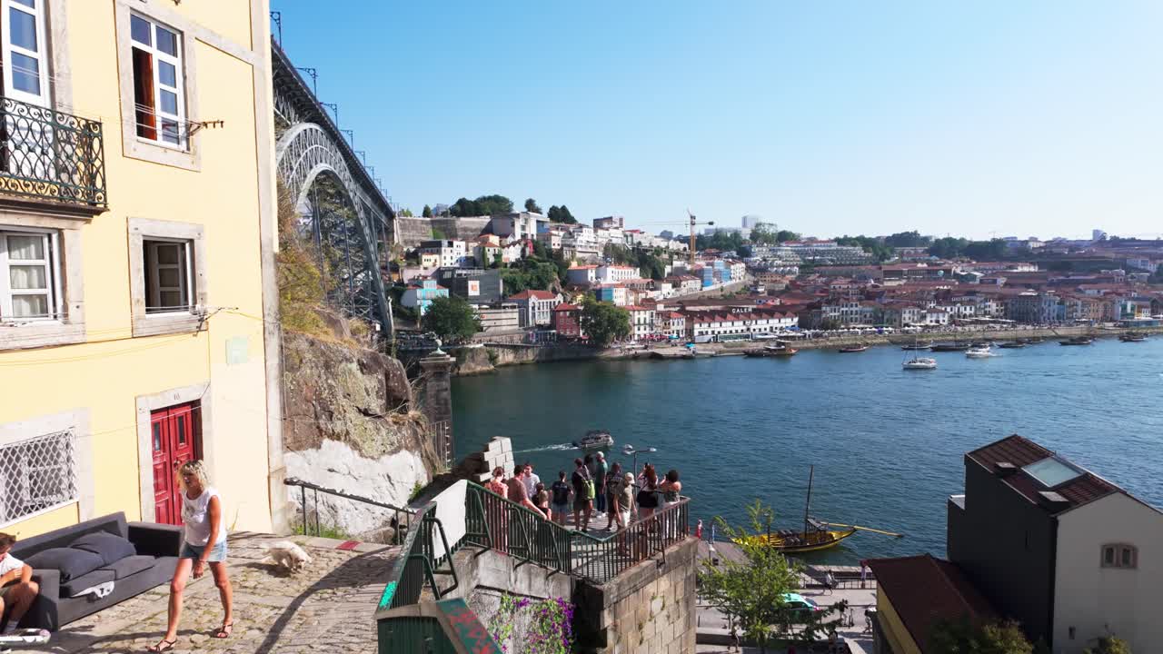 Graffiti-covered stairs leading down to the street near the Luís I Bridge in Porto on a sunny day