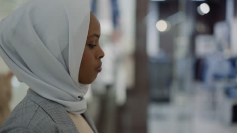 african-american woman with white hijab walks past stores