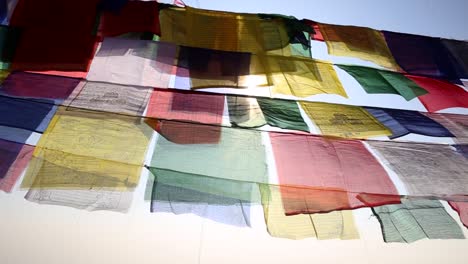 sun peeping through buddhist prayer flags in nepal