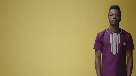 happy african man pointing and gesturing on yellow background