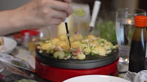 hand turning takoyaki dumplings, japanese home cooking