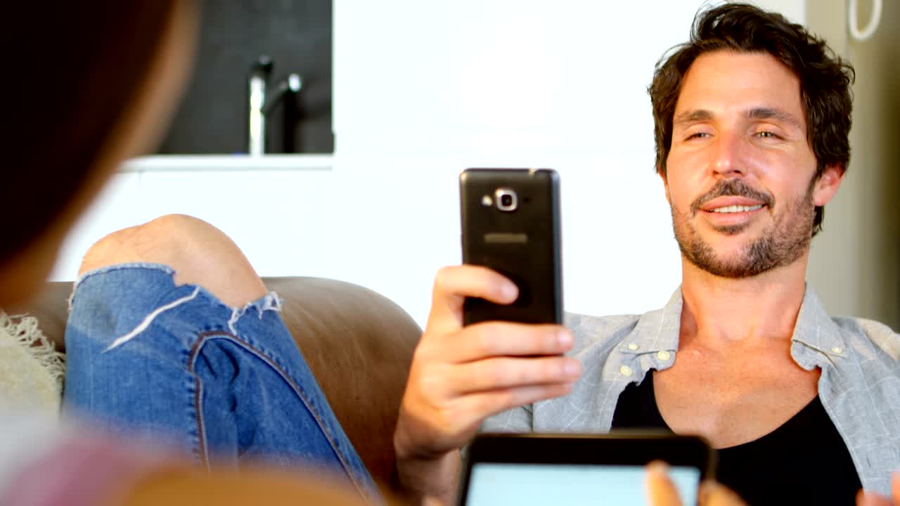 hombre haciendo clic en una foto de su mujer con teléfono móvil 4k