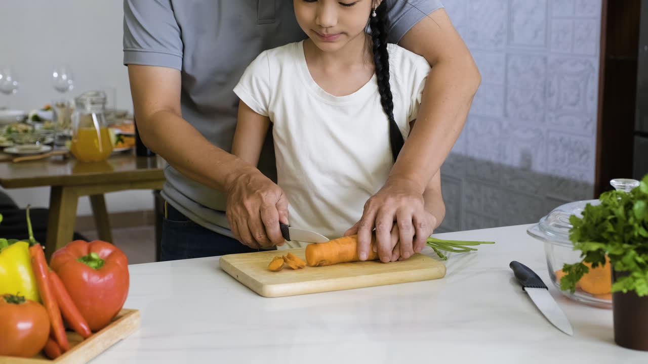 Father and daughter cutting carrot.
