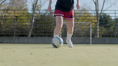 Low-Angle-Shot-Of-Girl-Wearing-Shorts-And-Dribbling-Football