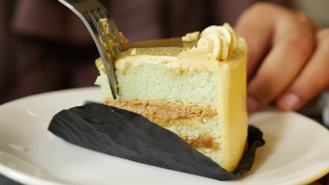 갈색 얼음으로 밝은 녹색 층층 케이크를 먹는 사람