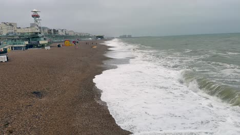 Capturando-Los-Elementos-Crudos-En-Un-Día-Nublado,-Este-Metraje-Escanea-La-Playa-De-Brighton,-Donde-Los-Fuertes-Vientos-Azotan-Las-Olas.