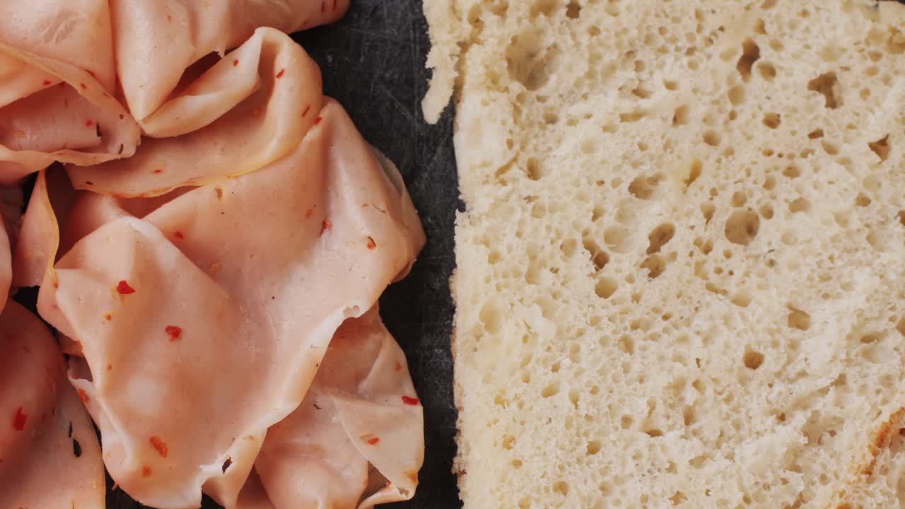 Ham italian mordatella, man Slices Of Traditional Italian antipasti mortadella sausage on a wooden cutting board, close up macro of chicken or turkey jamon, fat breakfast dish.