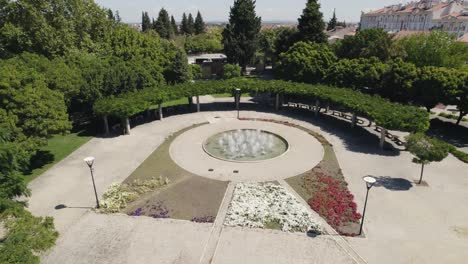 aerial parallax motion, public garden with flower patterns and water fountain - castelo branco