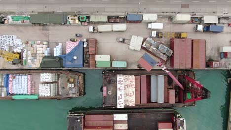 pequeñas barcazas de contenedores de tipo alimentador que operan en el muelle de pilar de hong kong