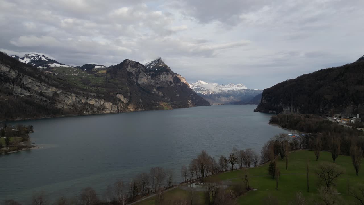 ascender por encima del campo de golf a lo largo de la costa del lago walen con picos de las montañas suizas en la distancia