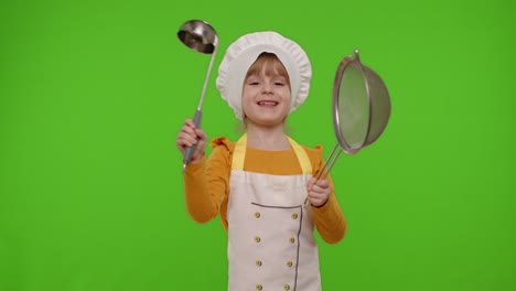 divertida niña cocinera chef panadero en delantal y sombrero bailando con tamiz y cuchara, haciendo tonterías