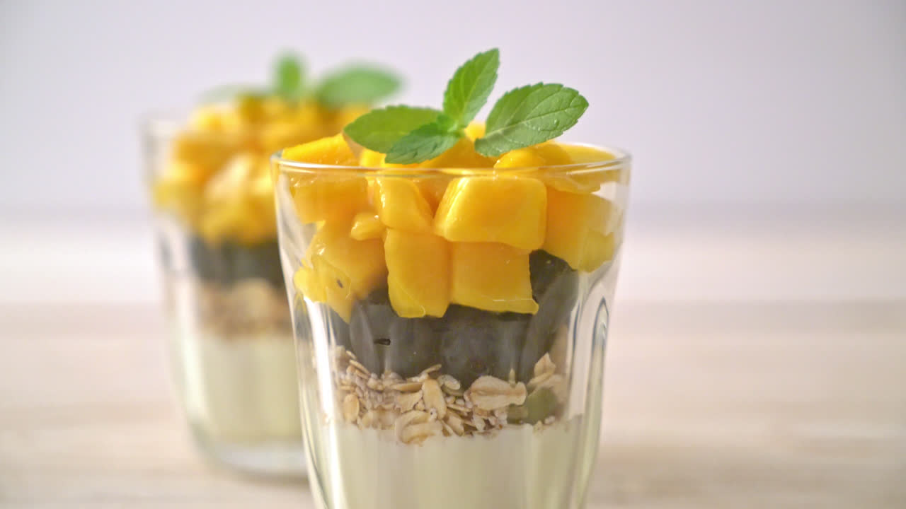 mango fresco casero y arándanos frescos con yogur y granola - estilo de comida saludable