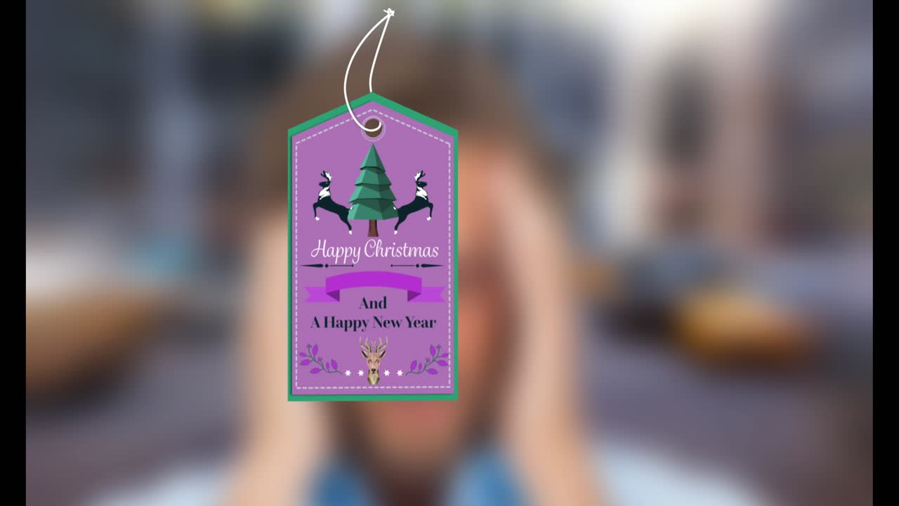 Animazione di un'etichetta regalo con la scritta "Buon Natale" e icone su sfondo sfocato.