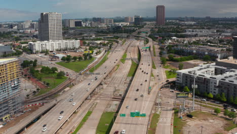 Forward-flying-drone-over-multi-lane-highway-heading-to-intersection.-Traffic-at-rush-hour.-Aerial-view-of-main-road-leading-through-town.-Dallas,-Texas,-US