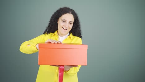 Mujer-Joven-Feliz-Y-Alegre-Abriendo-Paquete-De-Regalo.