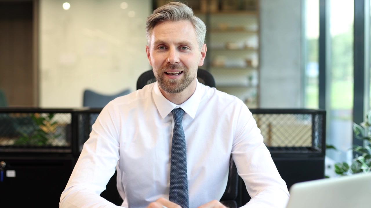 Selvsikker forretningsmand taler under et videoopkald på et moderne kontor