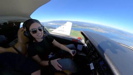 joven piloto con gafas de sol volando un pequeño avión privado, mirando a su alrededor y sonriendo