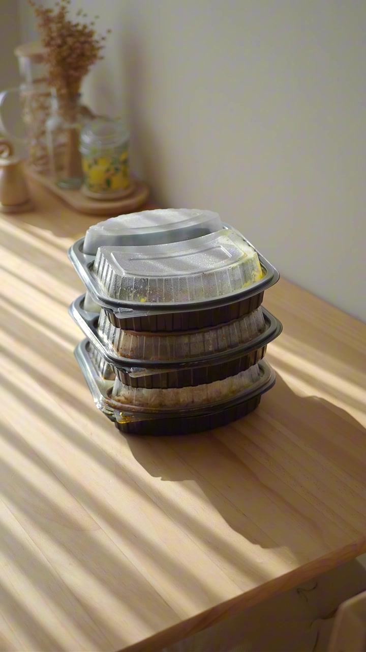 Pila de envases de comida para llevar en una mesa de madera