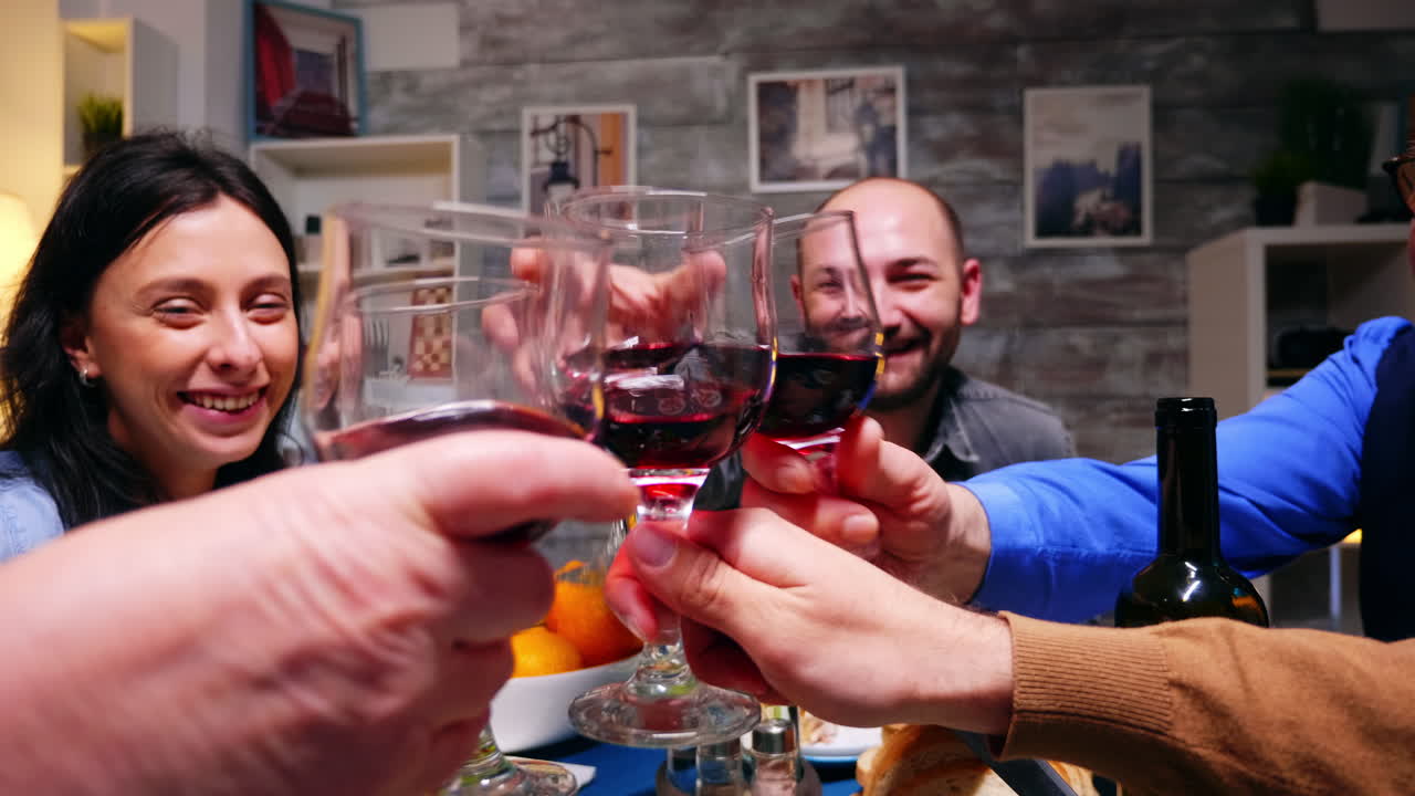 Zoom in shot of family clinking glasses of red wine