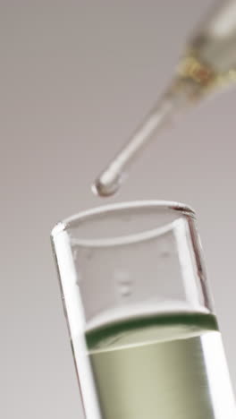 vertical video of laboratory pipette and test tube with copy space on white background