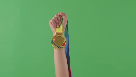 golden medal in hand. green screen background