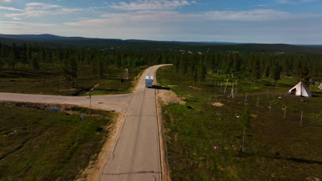 Aerial-view-rising-over-a-RV,-revealing-the-Saariselka-town,-summer-in-Finland