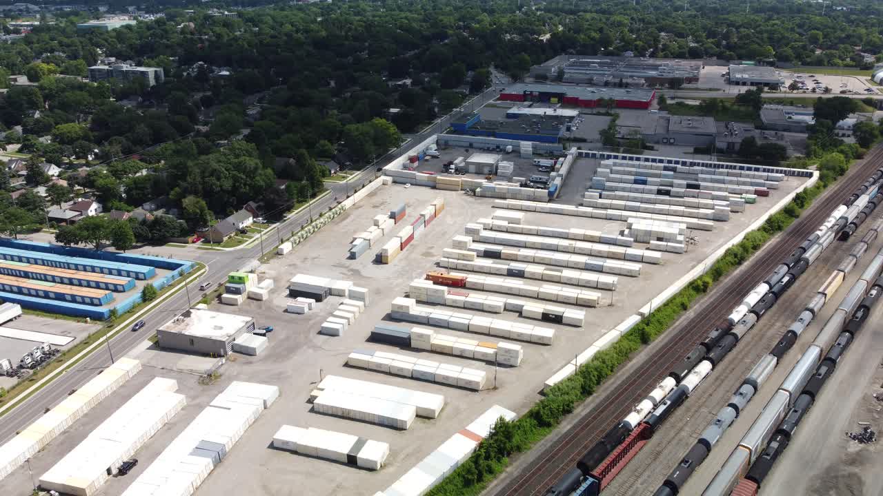 Storage containers beside a large rail road track, aerial footage for establishing scenes