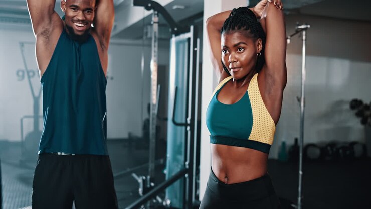 Paar dehnt sich im Fitnessstudio