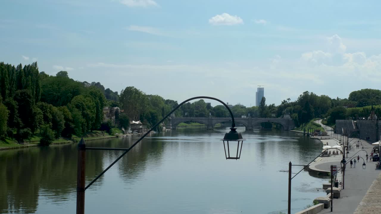 Static Shot of Blue Sky over River w Green Forests and Bridge in Turin Italy