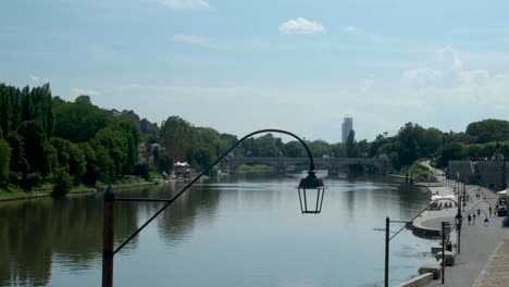 static shot of blue sky over river w green forests and bridge in turin italy