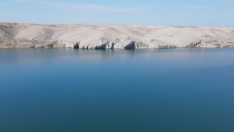 Pag,-calm-of-the-Adriatic-in-an-early-morning,-an-aerial-slide-with-drone