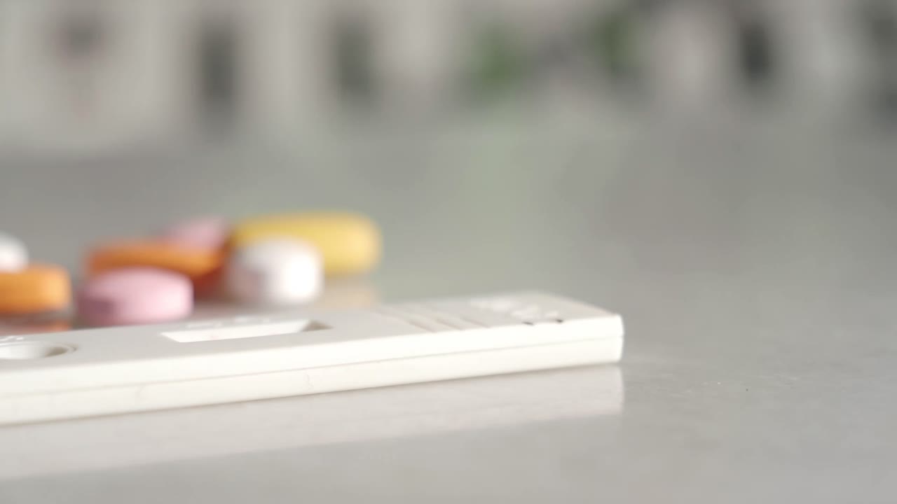 Medical Test Strip and Colorful Pills on a White Surface