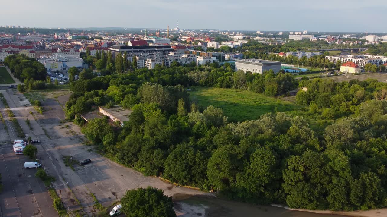 Cinematic drone circling of abandoned football pitch with overgrown trees in former stands - Edmund Szyc Stadium, Poznan