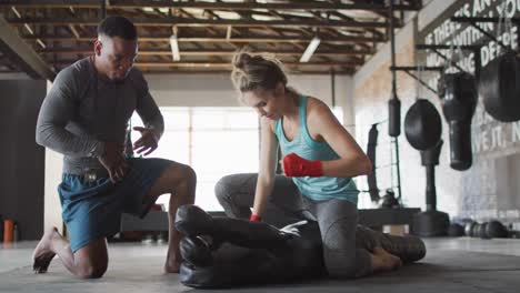 Video-of-fit-diverse-woman-and-man-preparing-for-training-at-gym