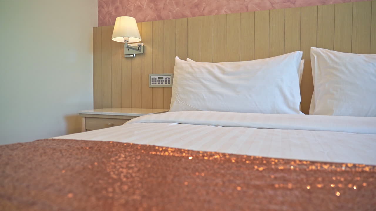 cerrar la cama con sábanas y cojines de color rosa brillante en la habitación del hotel
