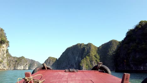 Crossing-Ha-Long-Bay-in-Vietnam-on-a-small-boat-with-bumper-tires,-Handheld-stable-shot