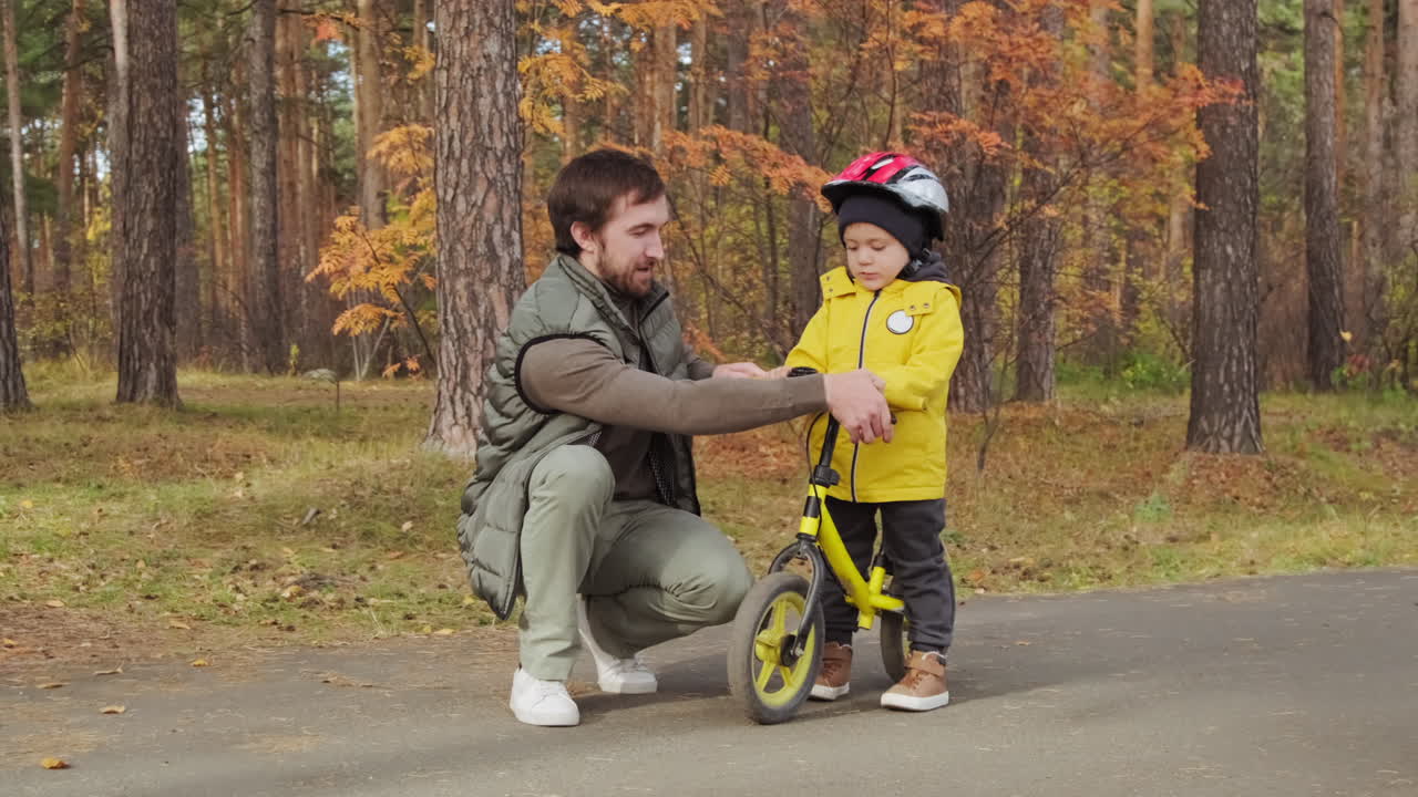 Father Teaching His Child to Ride a Bike in the Park
