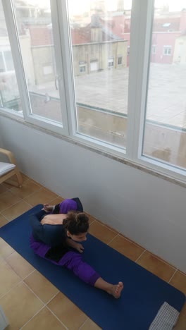 woman doing yoga stretches on a balcony