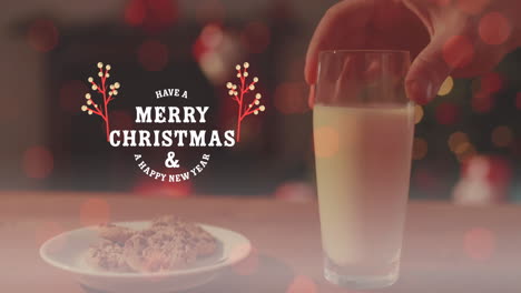 animación de feliz navidad y un texto de feliz año nuevo, recortado mano manteniendo galletas y vaso de leche