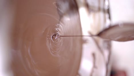 melted liquid chocolate pouring into bowl