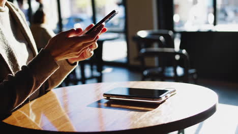 woman using phone in a cafe with wireless charging