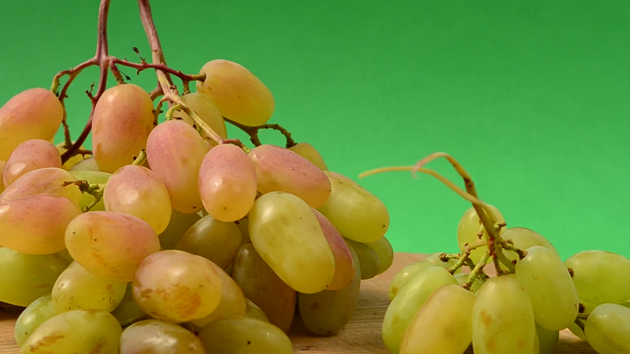 Uva su un tagliere da cucina. Ripresa in movimento